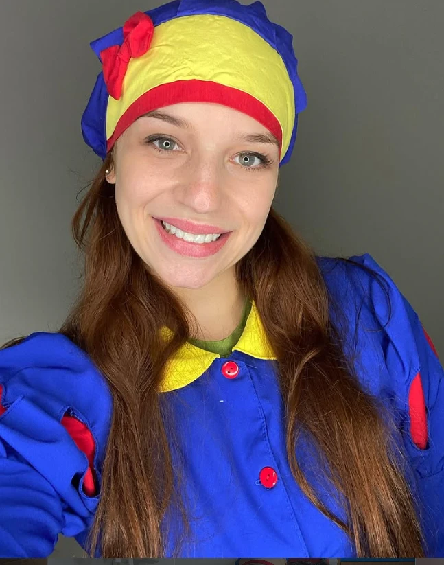 Dra. Rafaela Ayello caracterizada com touca colorida e jaleco azul, sorrindo